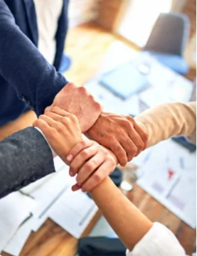 Colleagues joining hands as a team